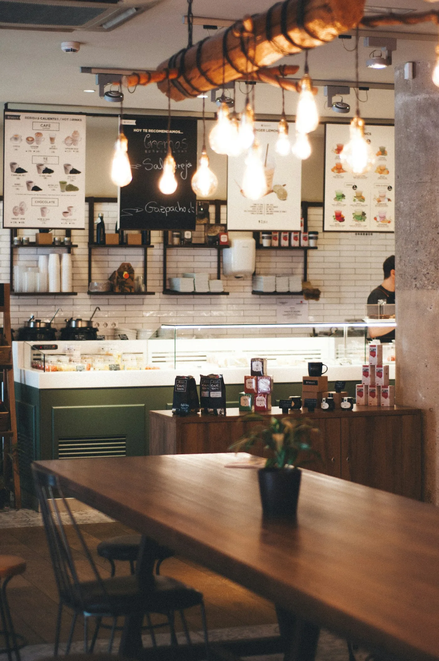 Interior de cafetería con madera y luces cálidas